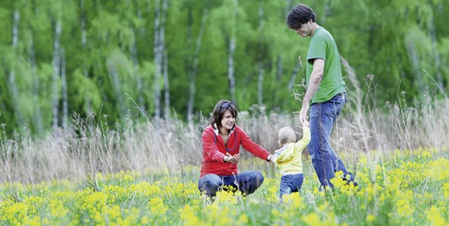 Eltern mit Kleinkind in einer Blumenwiese